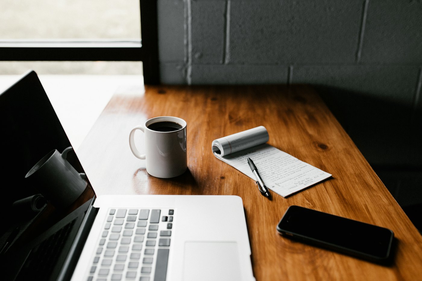 Una mesa con notebook, café y un teléfono