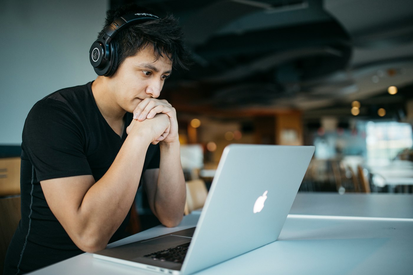 Una persona con auriculares mira la notebook